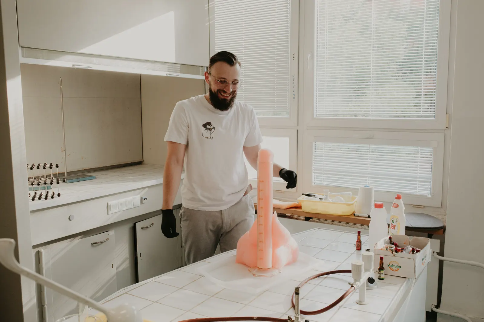 Chemik v laboratóriu pri stĺpe peny zo slonej zubnej pasty
